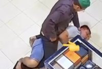 Oknum polisi terlihat berusaha mengeluarkan sesuatu diduga sabu dari saku celananya sendiri (moji tunjuk-red) saat membekuk dan menghimpit Rahmadi.(Ist)